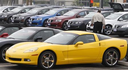 A car salesman walks through the parking lot at a General Motors dealership in Vienna, Virginia