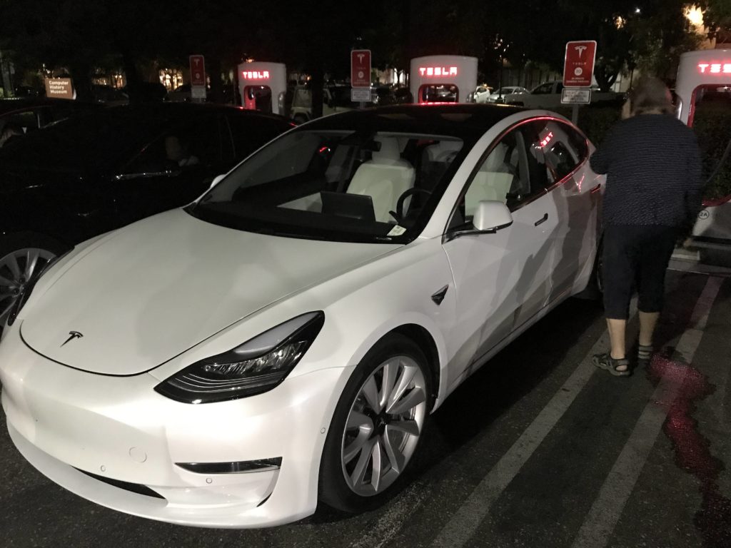 tesla model 3 white seats front mountain view supercharger