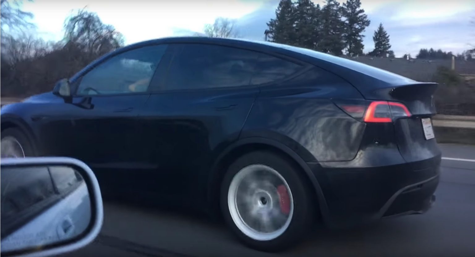 Black Tesla Model Y Performance with red brakes looking stealthy in new