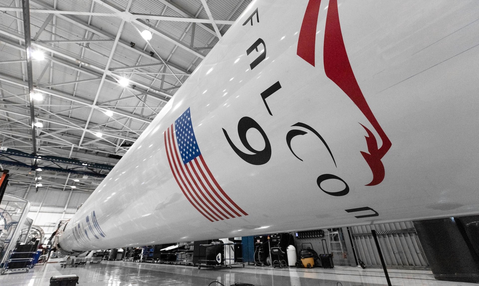Space Force officials say the Falcon 9 booster pictured here in SpaceX's rocket factory will have to wait a few months longer for its launch debut. (SpaceX)