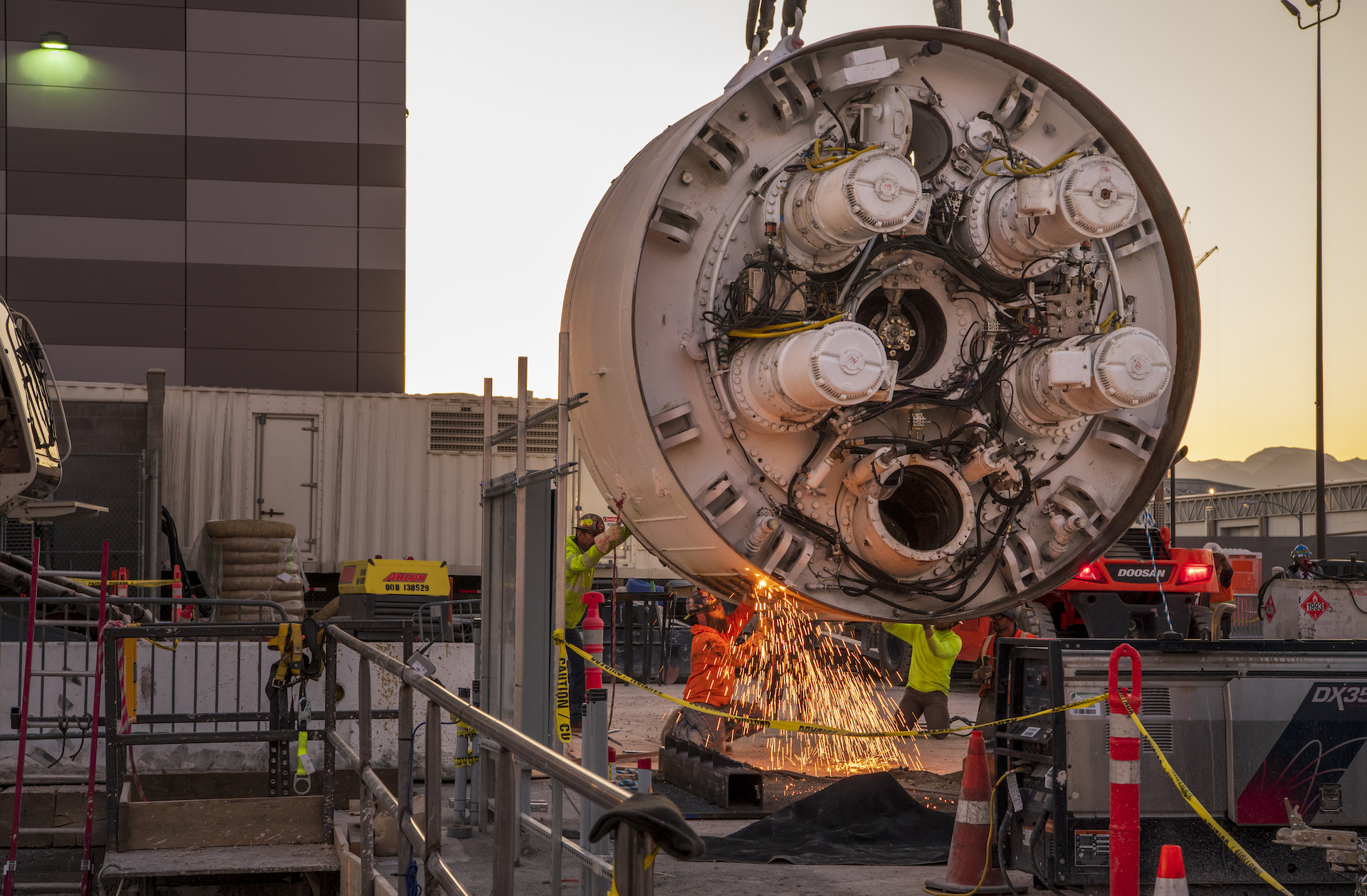 Workers cut the storage rack from the base of the drill head as the Boring Company prepares to lower the drill head for the People Mover tunnel which will connect convention halls as part of the LVCCD Phase 2 construction in the Red Lot east of the south Hall at the Las Vegas Convention center on Monday, Oct. 28, 2019. (Mark Damon/Las Vegas News Bureau)