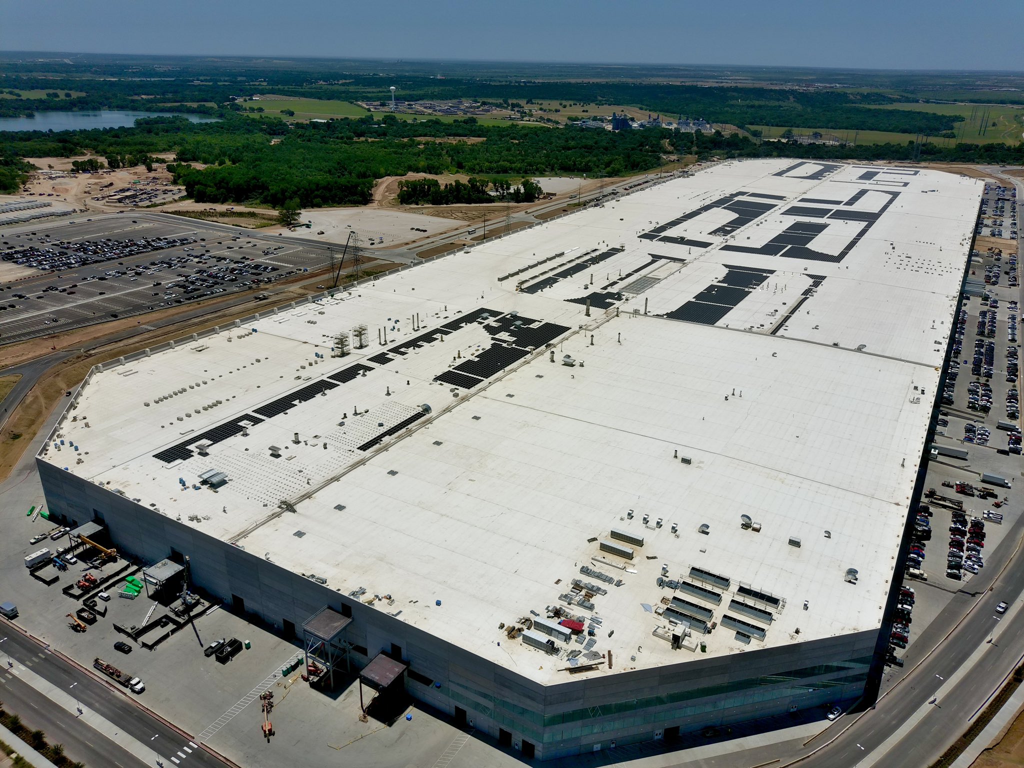 photo of Tesla’s self-inscription atop Gigafactory Texas with solar panels continues image