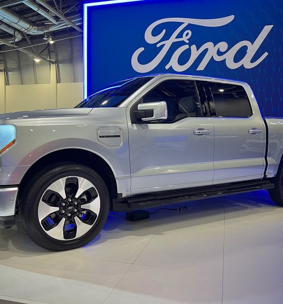 ford f-150 lightning in front of ford logo