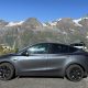 tesla model y in front of mountain range