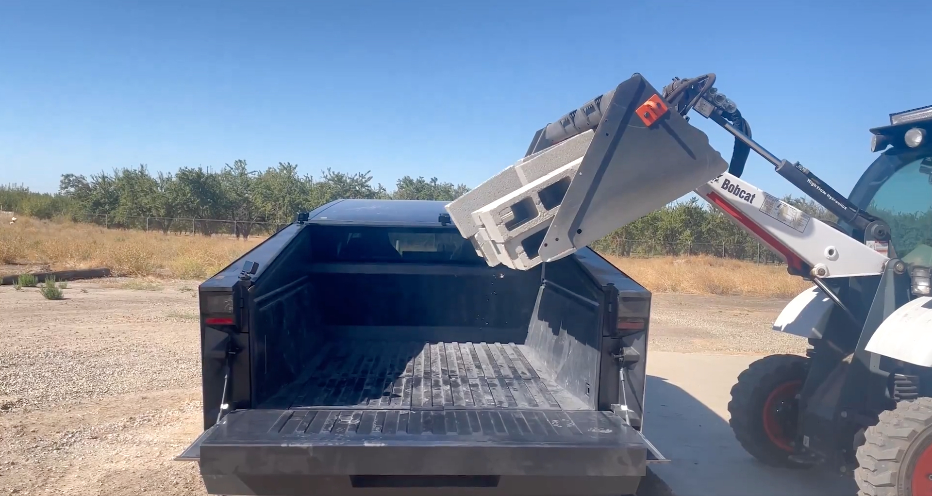tesla-cybertruck-taking-a-dump-truck-bed-cinder-block-test