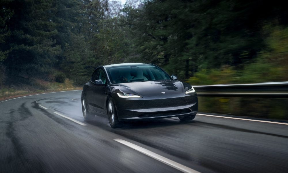 tesla model 3 driving on a wet road