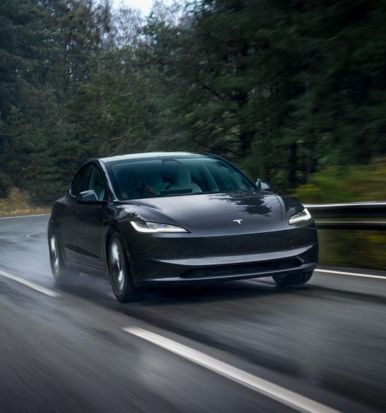tesla model 3 driving on a wet road
