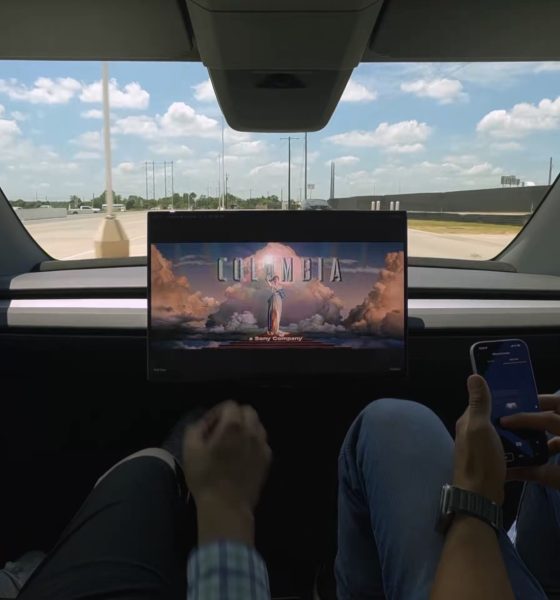 tesla cybercab with no manual controls showing a movie with two employees inside