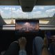 tesla cybercab with no manual controls showing a movie with two employees inside
