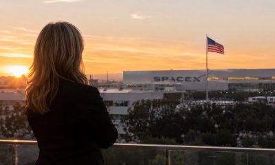 Concept rendering of SpaceX President Gwynne Shotwell overlooks the company’s Hawthorne, California headquarters as an American flag flies over the campus at sunset.