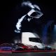 Tesla’s new Roadster, upside down and trailing cold gas thruster smoke, flips over a lineup of Tesla vehicles at the Roadster unveiling near Waco, Texas on October 15, 2026. (Image: Tesla)